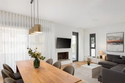 a living room with a dining room table and a tv at Glyfada Experience Residence in Athens