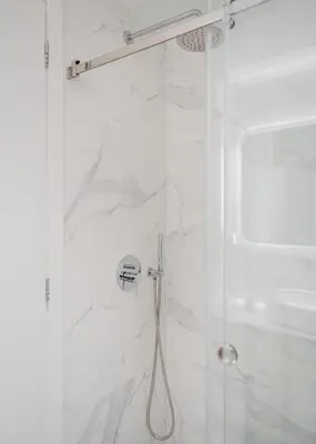 a bathroom with a shower with a glass door at Glyfada Experience Residence in Athens