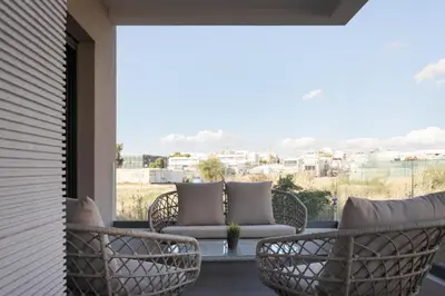 a patio with chairs and a table on a balcony at Glyfada Experience Residence in Athens