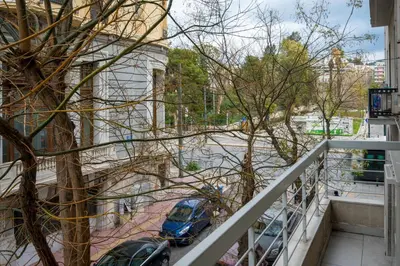 a balcony with a blue car parked on a street at Mia Homes - National Museum in Athens