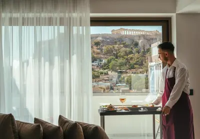 a man standing in a room with a table with food at Eternity Athens in Athens