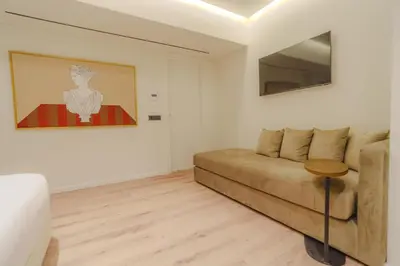 a living room with a couch and a painting at Eternity Athens in Athens