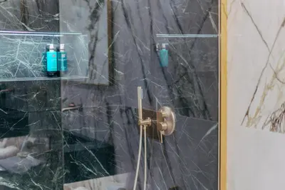 a shower with a glass door with two shampoo bottles at Eternity Athens in Athens