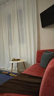 a living room with a red couch and a table at ATHENS O'GERA escape in Athens