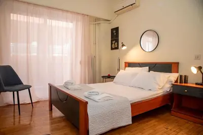 a bedroom with a bed and a chair and a mirror at Piraeus Pasalimani X6 near metro in Piraeus