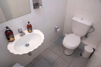 a white bathroom with a toilet and a sink at Piraeus Pasalimani X6 near metro in Piraeus