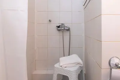 a white shower with a stool in a bathroom at Piraeus Pasalimani X6 near metro in Piraeus