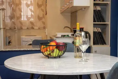 a table with a bowl of fruit and a wine glass at Piraeus Pasalimani X6 near metro in Piraeus