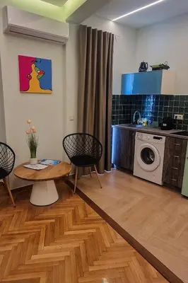 a living room with a table and a washing machine at New Luxury Studio, Near Hilton, Central , Ventiri Suite 7 in Athens