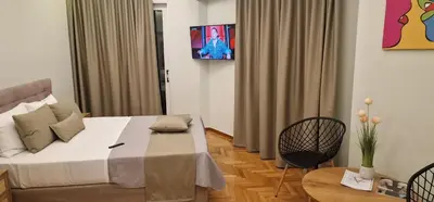 a bedroom with a bed and a table and a tv at New Luxury Studio, Near Hilton, Central , Ventiri Suite 7 in Athens