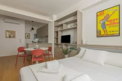 a bedroom with a white bed and a table with chairs at Perfect Spot! Studio in Kolonaki in Athens