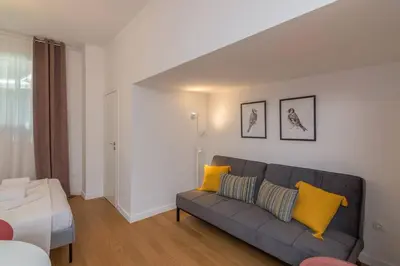 a living room with a gray couch and yellow pillows at Perfect Spot! Studio in Kolonaki in Athens