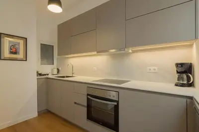 a kitchen with white cabinets and a stove top oven at Perfect Spot! Studio in Kolonaki in Athens