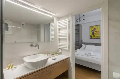 a white bathroom with a sink and a bed at Perfect Spot! Studio in Kolonaki in Athens