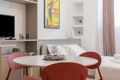 a living room with a white table and red chairs at Perfect Spot! Studio in Kolonaki in Athens