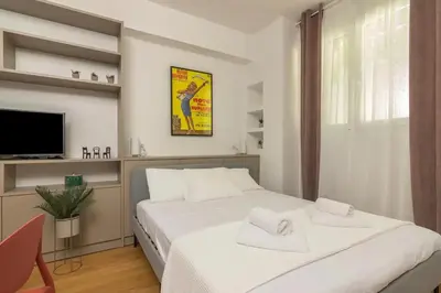 a bedroom with a white bed and a tv at Perfect Spot! Studio in Kolonaki in Athens