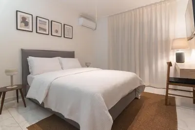 a white bedroom with a bed and a desk at Prime Location Kolonaki Burrow in Athens