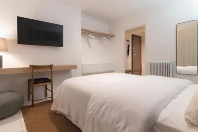 a white bedroom with a bed and a desk at Prime Location Kolonaki Burrow in Athens