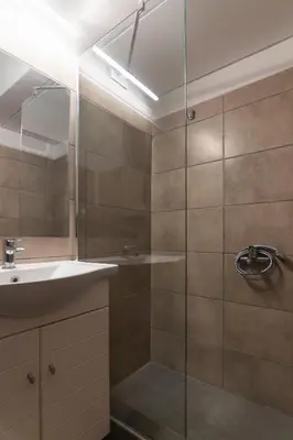 a bathroom with a shower with a sink and a mirror at Prime Location Kolonaki Burrow in Athens