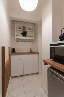 a kitchen with white cabinets and a counter top at Prime Location Kolonaki Burrow in Athens
