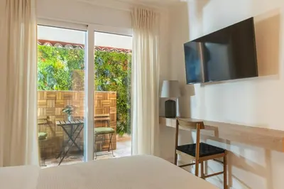 a bedroom with a bed and a sliding glass door to a patio at Prime Location Kolonaki Burrow in Athens