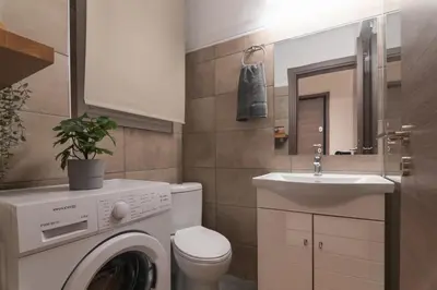a bathroom with a washing machine and a sink at Prime Location Kolonaki Burrow in Athens