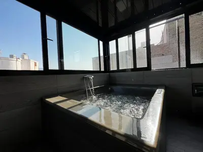 a bath tub with a shower in a room with windows at Private hottub Athens Skythens omonoia in Athens