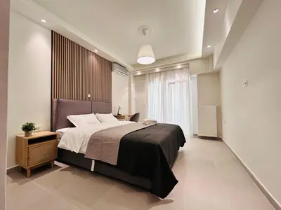 a bedroom with a large bed and a large window at T seaside cozy APT in Athens