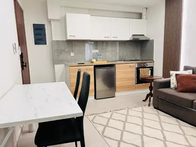 a kitchen and living room with a table and a couch at T seaside cozy APT in Athens