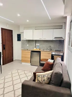 a living room with a couch and a kitchen at T seaside cozy APT in Athens