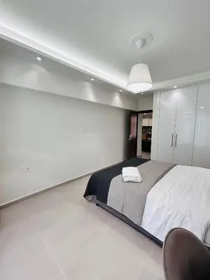 a bedroom with a large bed and a chair at T seaside cozy APT in Athens