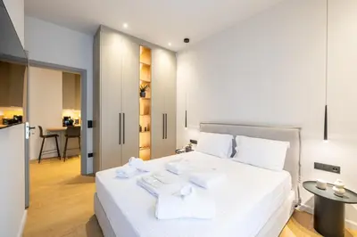 a bedroom with a white bed with towels on it at Rooms151 Business Suite in the Heart of Athens 2nd floor-5 in Athens
