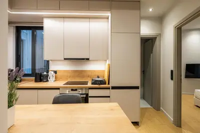 a kitchen with white cabinets and a wooden table at Rooms151 Business Suite in the Heart of Athens 2nd floor-5 in Athens