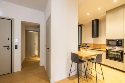 a kitchen with white walls and a wooden table and chairs at Rooms151 Business Suite in the Heart of Athens 2nd floor-5 in Athens