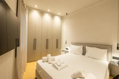 a bedroom with a white bed with towels on it at Rooms151 Business Suite in the Heart of Athens 2nd floor-5 in Athens