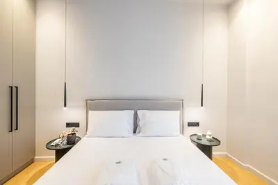 a bedroom with a large white bed with two tables at Rooms151 Business Suite in the Heart of Athens 2nd floor-5 in Athens