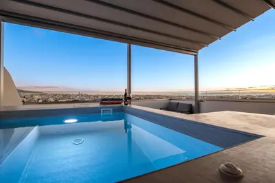a swimming pool with a view of the desert from a house at Elite Penthouse with Heated Pool and SkylineView in Piraeus