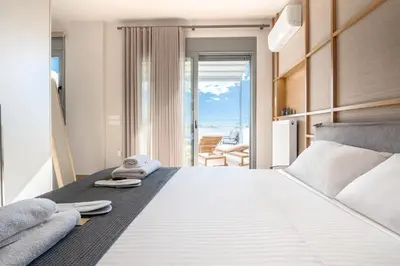 a bedroom with a bed with a view of the ocean at Elite Penthouse with Heated Pool and SkylineView in Piraeus