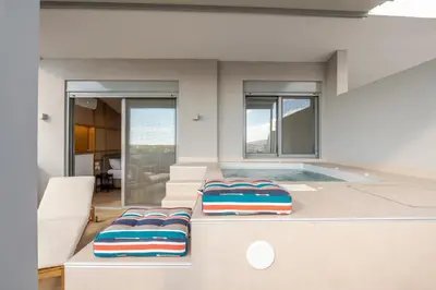 a living room with a swimming pool and two chairs at Elite Penthouse with Heated Pool and SkylineView in Piraeus