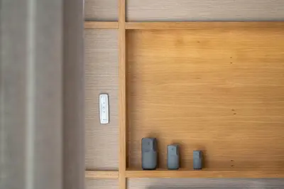 a wooden cabinet with three remote controls on it at Elite Penthouse with Heated Pool and SkylineView in Piraeus