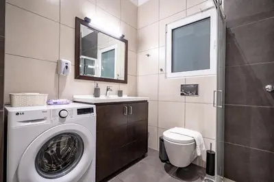 a bathroom with a washing machine and a sink at Evaggelismos Apt Metro Station 1 bdrm 2pers by MPS in Athens