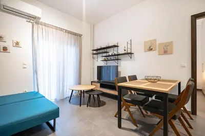 a living room with a dining room table and a tv at Evaggelismos Apt Metro Station 1 bdrm 2pers by MPS in Athens