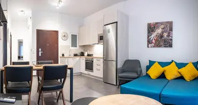 a living room with a blue couch and a kitchen at Evaggelismos Apt Metro Station 1 bdrm 2pers by MPS in Athens