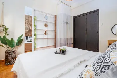 a bedroom with a white bed and a black door at 4BED Apartment in the heart of Athens in Athens