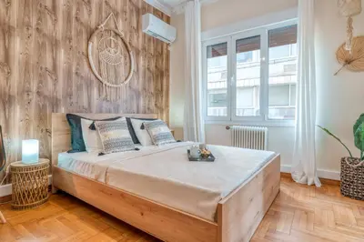 a bedroom with a large bed with a wooden wall at 4BED Apartment in the heart of Athens in Athens