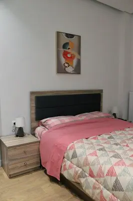 a bedroom with a bed and a wooden night stand at Golemis Apartments in Athens