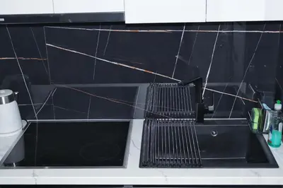 a kitchen sink with a black tile wall at Golemis Apartments in Athens