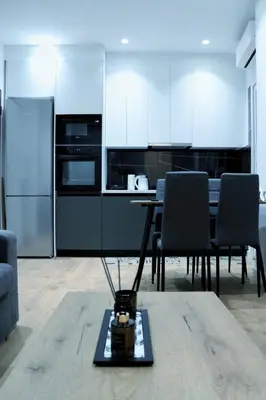 a kitchen with white cabinets and a table and chairs at Golemis Apartments in Athens