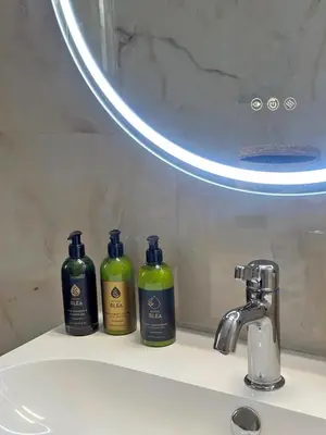 three bottles of soap sitting on a bathroom sink at Agora Apt2, Metro Station, 2 bdrms in Athens