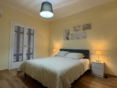 a bedroom with a large bed and a lamp at Cecilia's cozy flat in Athens